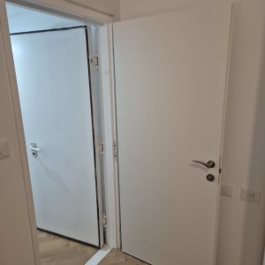 דלתות לבנות פתוחות עם ידיות מתכת