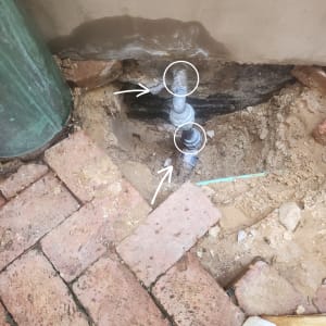 צינור מים עם סימני דליפה באדמה חשופה