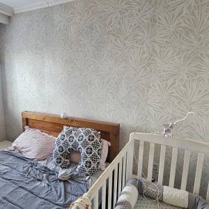 חדר שינה עם טפט על הקיר ומיטת תינוק