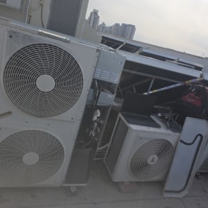 יחידות מיזוג אוויר על גג עם מחשב נייד ותיק.