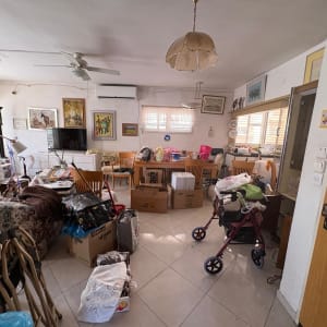 חדר עם קופסאות וציוד לאריזה, מתאים לפינוי בית