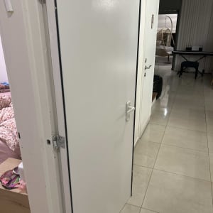 דלת לבנה פתוחה עם ידית וחלקים נוספים