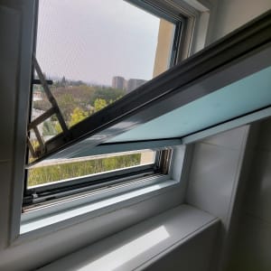 חלון אלומיניום פתוח עם מסגרת מתכת