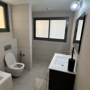 חדר אמבטיה נקי עם שירותים וכיור