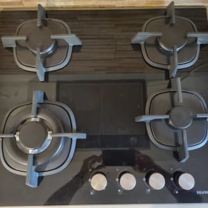 כיריים גז עם ארבעה מבערים וכפתורי שליטה.