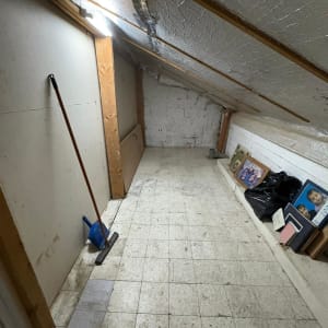 חדר עליית גג עם מטאטא ותמונות על הרצפה