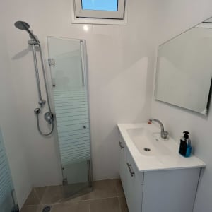 מקלחת חדשה עם דלת זכוכית וברז מודרני