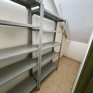 מדפים ריקים בחדר קטן עם קירות לבנים