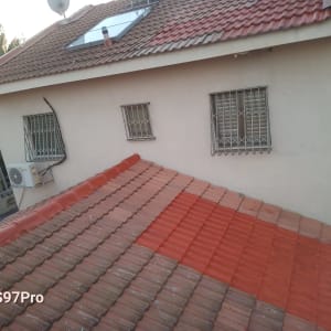 גג רעפים אדום עם קולטי שמש ואנטנה