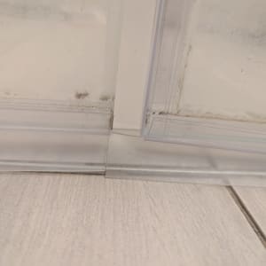 תקריב של דלת מקלחת עם סימני עובש