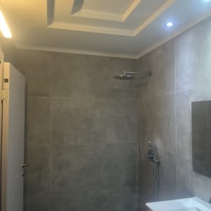 חדר אמבטיה משופץ עם מקלחת חדשה ותאורה מודרנית