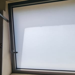 חלון עם תריסים סגורים ומסגרת מתכת אפורה