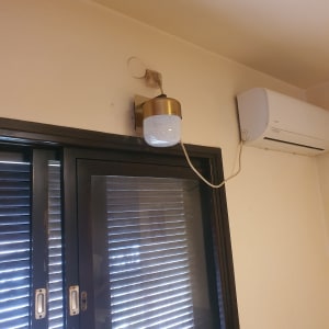 מנורה מותקנת על קיר ליד חלון ומזגן