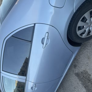 מכונית כחולה עם חלונות כהים וחישוקי גלגלים