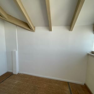 קיר גבס לבן עם קורות עץ בתקרה