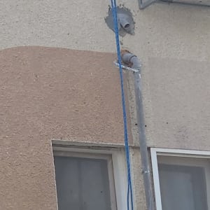 צינור מותקן על קיר חיצוני עם מזגן