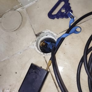 כלי עבודה וצינור ליד פתח ניקוז ברצפה