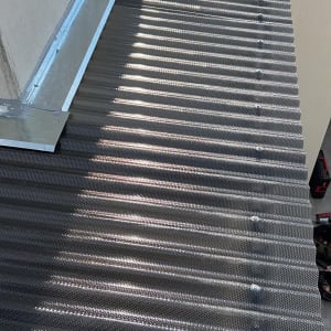 גג מתכת גלי עם ברגים לאורך הקצוות