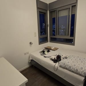 חדר עם מיטה, חלונות וכלים על המיטה