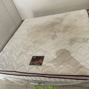 מזרן עם כתמים על רצפת אריחים