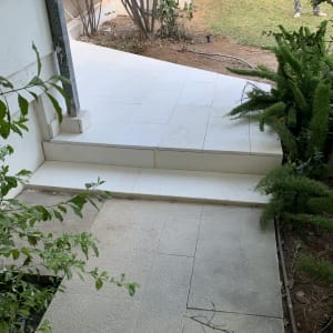 ריצוף חוץ באריחי אבן וספסל בנוי ומחופה בחצר בית פרטי