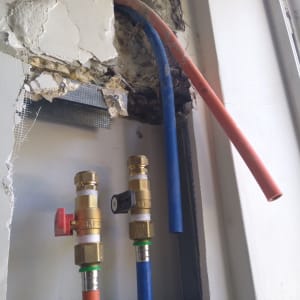 צינורות מים וסתומים בקיר פתוח