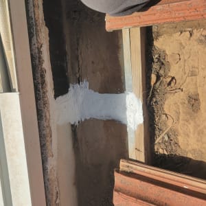 איטום עם חומר לבן על משטח עץ ואדמה