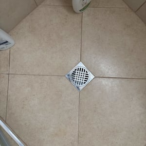 רצפת מקלחת עם ניקוז ובקבוקי שמפו