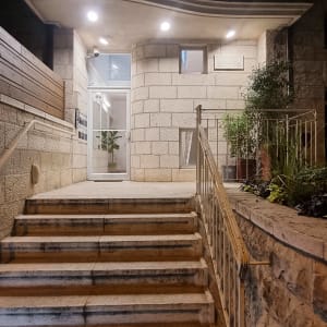 כניסה לבניין עם מדרגות ותאורה חיצונית