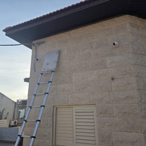 סולם ליד קיר עם מצלמות אבטחה מותקנות