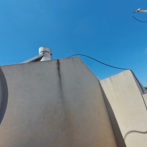 קוצים על קיר למניעת יונים על רקע שמיים כחולים