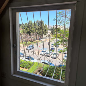 חלון עם סורגי מתכת ונוף חיצוני