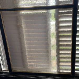 זכוכית עם דוגמת בועות ותריסים מאחוריה