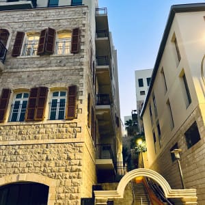 מבנה מגורים רב קומות עם חיפוי אבן וחלונות בסמטה