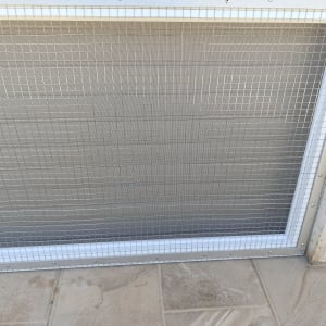 מסגרת אלומיניום עם רשת מתכת על קיר