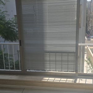 וילון ונציאני על חלון עם אור שמש