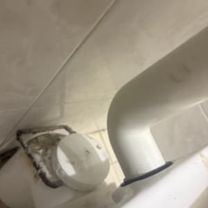 צינור לבן מחובר לקיר בחדר אמבטיה