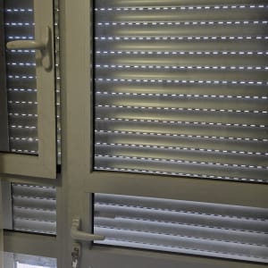 תריסים סגורים על חלון עם ידית ומפתח