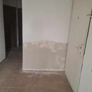 קיר עם סימני תיקון צבע ליד דלת
