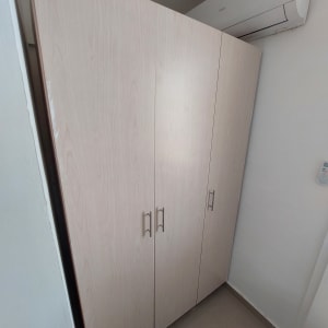 ארון עץ עם ידיות מתכת מותקן ליד מזגן