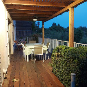 פרגולה מעץ עם שולחן וכיסאות בגינה