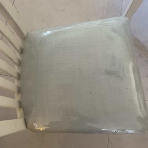 כיסא עם ריפוד בד בהיר על רצפת שיש