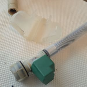 צינור עם מחבר ירוק על משטח לבן