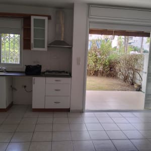 מטבח ריק עם חלון ודלת פתוחה לחצר