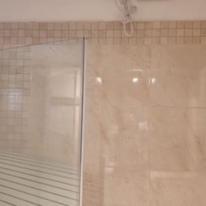 מחיצת זכוכית למקלחת עם מסגרת מתכת