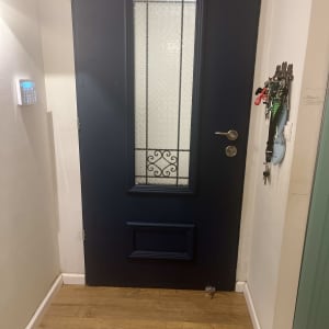 דלת כחולה עם חלון זכוכית מעוצב וידית מתכת