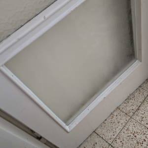 זכוכית מחוספסת במסגרת לבנה על דלת