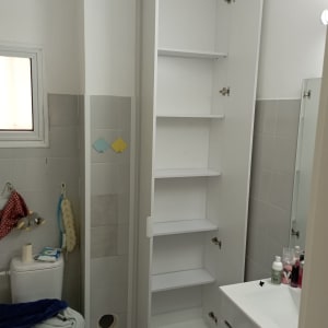 ארון לבן עם דלתות פתוחות בחדר אמבטיה