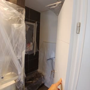 חדר אמבטיה עם כיסוי ניילון על הקירות והדלת