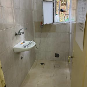 כיור עם ברז בחדר אמבטיה עם קירות אריחים